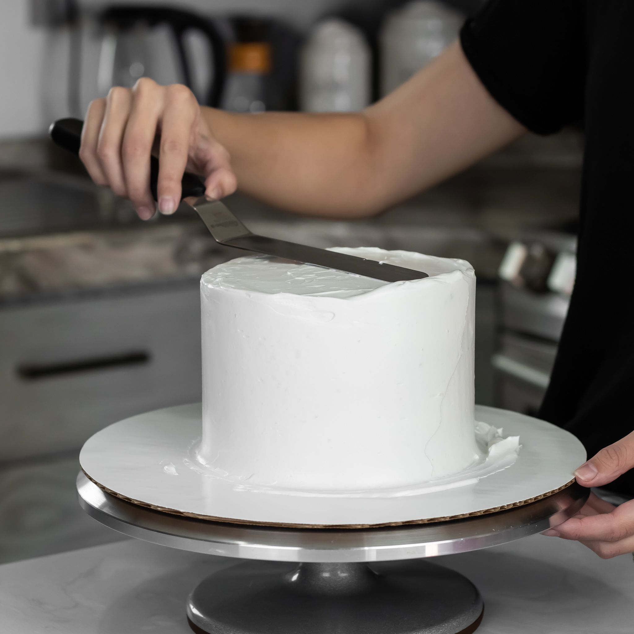 smoothing whipped cream cake with offset spatula